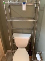 Bathroom shelf unit standing over a toilet, showing three wire shelves and chrome finish.