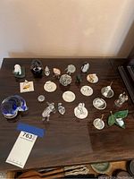 Overview of entire collection on table, showing multiple glass animals and miniatures with mirror pedestals