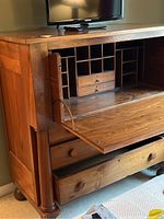 Open secretary compartment showing small drawers and cubbyholes inside.