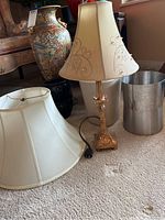 Wide shot showing the main items: two tall vases, a lamp with floral embroidered lampshade, a second plain white lampshade, and a silver trash can.