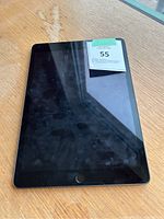 Front view of iPad showing black bezel, home button, smudged screen.