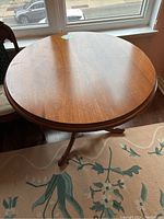 Top view of the round wooden table showing the surface with natural wood grain and some scratches.
