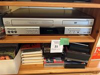Photo showing Panasonic VHS and DVD combo player on shelf with AV inputs and control buttons.