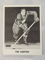 Front side showing Tim Horton skating in Toronto Maple Leafs uniform with stick on ice