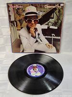 Vinyl record of Elton John Greatest Hits LP with visible writing on the label and good condition of the vinyl surface.