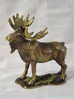 Side view of the moose figurine showing detailed antlers and jeweled spots on its body.