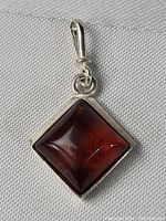 Clear close-up image of the front of the amber pendant mounted in sterling silver.
