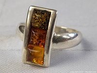 Front view of the rectangular sterling silver ring with three amber stones in distinct colors.