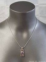 Necklace displayed on a bust showing the pendant's size and chain type.