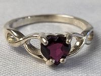 Front view showing the heart-shaped carved amethyst in four-prong sterling silver setting with decorative band sides.
