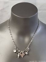 Front view of necklace displaying all charms and chain link style on mannequin.