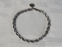 Top view of the full circular sterling silver twisted rope chain bracelet, showing the entire length on a white background.