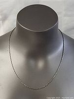 Full view of the 20-inch sterling silver necklace displayed on a gray mannequin bust.