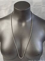 Full view of the sterling silver necklace displayed on a mannequin torso, showing length and chain style.