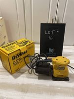 Overall photo showing Dewalt sander, its power cord, and original yellow box with model and branding.
