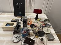 Overview of lot with various used electrical boxes, switch plates, screws, red warning light, and packaged connectors.