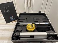 Top view of LazerPro laser level kit inside carrying case, showing laser level, tripod, and spirit level arranged neatly in custom slots.