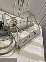 Photo of the power bars arranged on a table displaying multiple electrical outlets and cords.