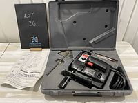 Open grey hard plastic carrying case showing black and red Sears Craftsman electric scroller saw with attached power cord, an accessory, and pocket with blade inside. Manual and lot information card placed beside the case.