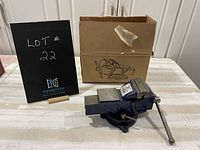 Front view of the blue swivel base vise with original box behind it, showing the overall size and condition of the vise.