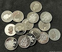 15 Canadian 50-cent coins in various conditions showing obverse with Queen Elizabeth II and reverse with Canadian coat of arms.