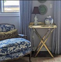 Tray table positioned next to upholstered chair in room setting