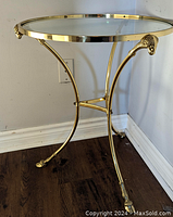 Full view of gueridon side table showing brass frame and glass top