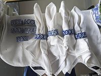 Overview of 13 blue and white ceramic napkin rings and white textured napkins with Ralph Lauren Home label