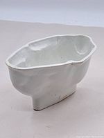 Side view of the vintage white ceramic bunny-shaped food mold showing overall shape and base.