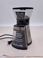 Front view of the Cuisinart Conical Burr Grinder showing the bean hopper, control panel, and metal exterior with power cord.