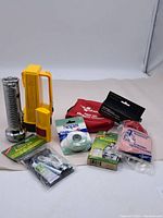 Wide view of all items in the lot visible including flashlights, batteries, first aid kit, tapes, and bandages.