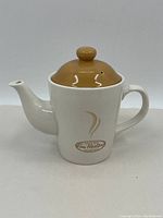 Full view of the Tim Hortons porcelain teapot with a brown lid and white body showing the shape and design.