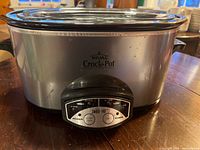 Front view of a Rival Crock Pot with stainless steel body and digital control panel.