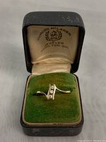 Ring displayed in Gordon McLaren jeweler box on green velvet cushion