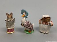 Front view of all three Beswick porcelain Beatrix Potter figurines showing mouse, Jemima Puddle-Duck, and cat characters.