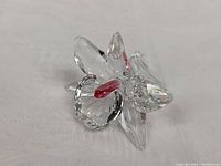 Front close-up of the clear Swarovski crystal flower showing pink center and petals.