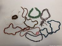 Full collection of assorted vintage beaded jewelry comprising various necklaces and bracelets with semi-precious stones.