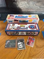Photo showing 1991 and 2006 Topps baseball card boxes on floor with three loose cards including Derek Jeter and Paul Goldschmidt.