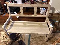 Front view of the wooden bench showing backrest and seat worn finish.