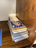 Stack of multiple US and Canadian coin set boxes on wooden shelf