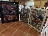 Three framed prints on tile floor showing all items
