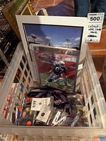 Basket with framed signed football player print and various unopened and loose sports collectible card packs