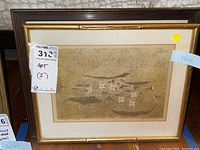 Framed Asian lithograph print showing stylized boats and figures in gold-toned bamboo-style frame with matting, labeled size 12x14 inches, with price tag visible.