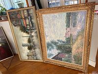 Both paintings side by side leaning against a wall