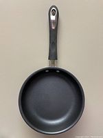 Top view showing the black non-stick interior of the skillet with smooth cooking surface and ergonomic handle with hanging hole.