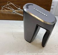 Close-up view of metallic gray Cuisinart cordless hand mixer with attached stainless steel beaters.
