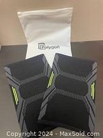 Front view of both knee compression sleeves laid out flat with Polygon logo on packaging behind.