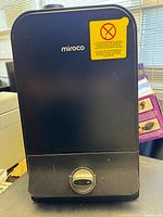 Front view of black Miroco cool mist humidifier with control dial and brand name, showing minor scratches.