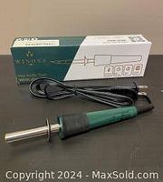 Boxed WINONS hot cutting utensil tool with dark green handle and attached power cord, displayed next to its original packaging box.