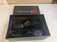 Black Bostonian men's dress shoes in original box, showing top view and packaging.